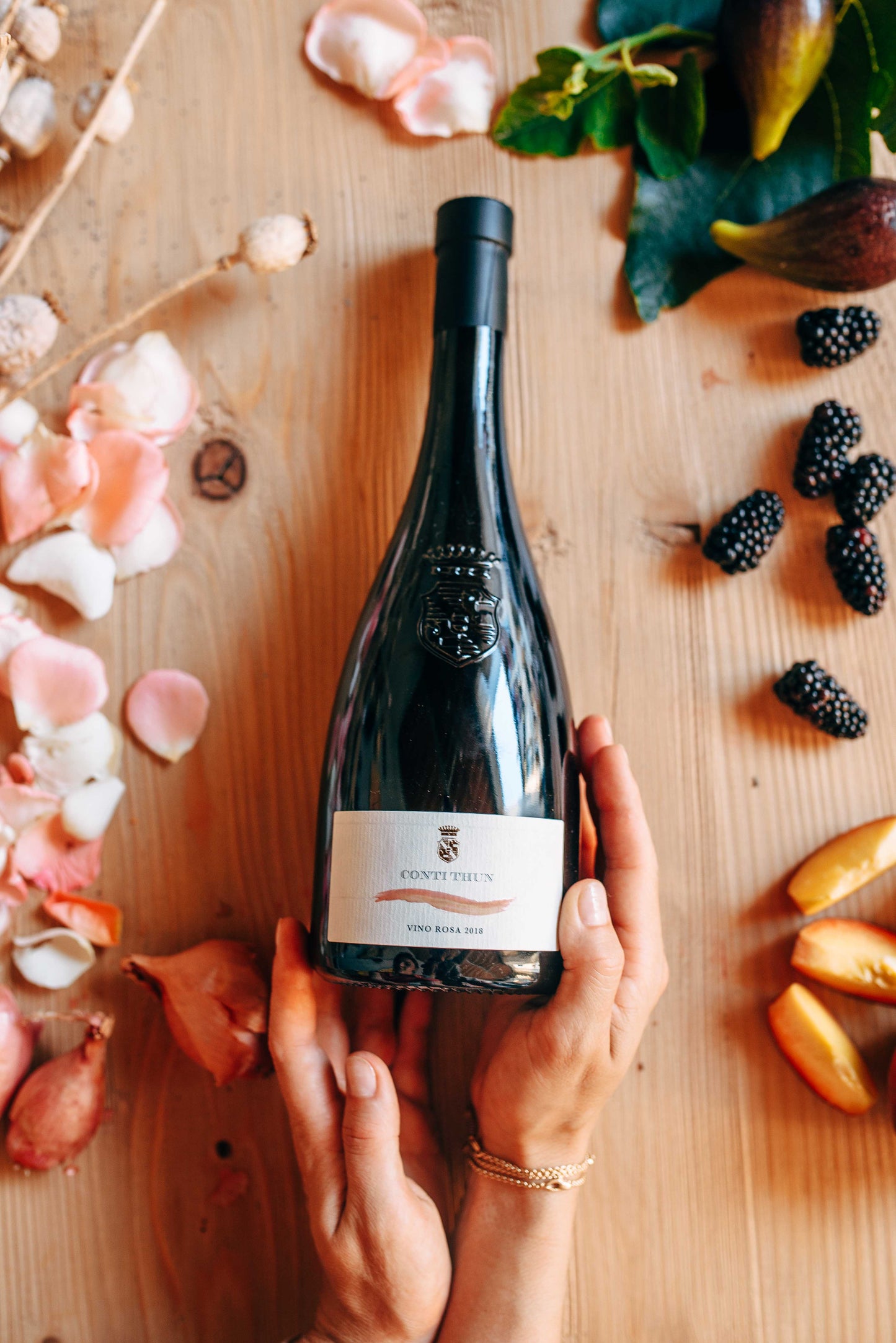 mani tengono vino rosa rosè conti thun dai sapori di mora, fichi, pesche e petali di rosa